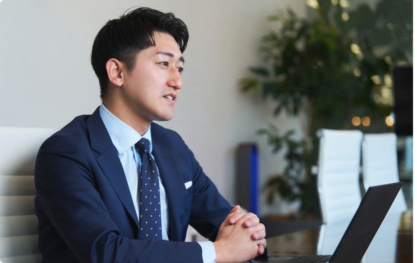 男性社員が笑顔でインタビューに回答している様子